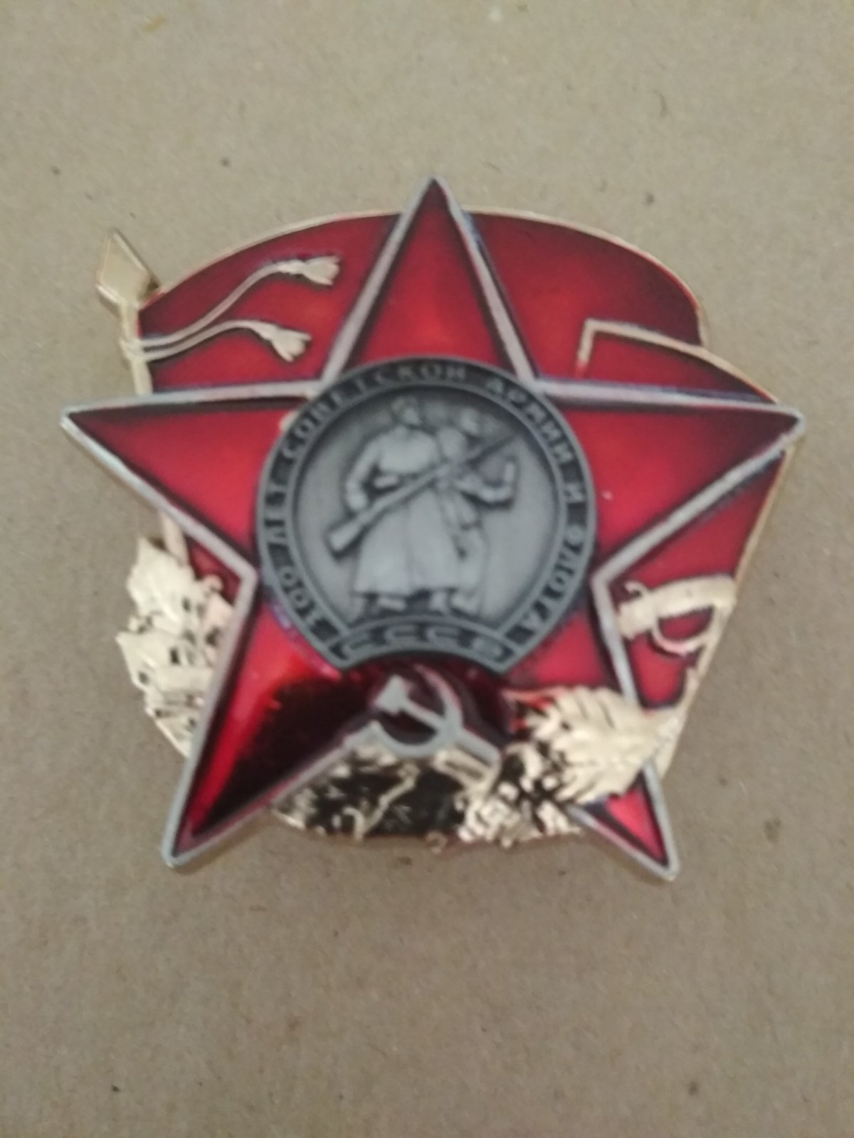 Знак "100 лет советской армии и флота" красная звезда на фоне красного флага.