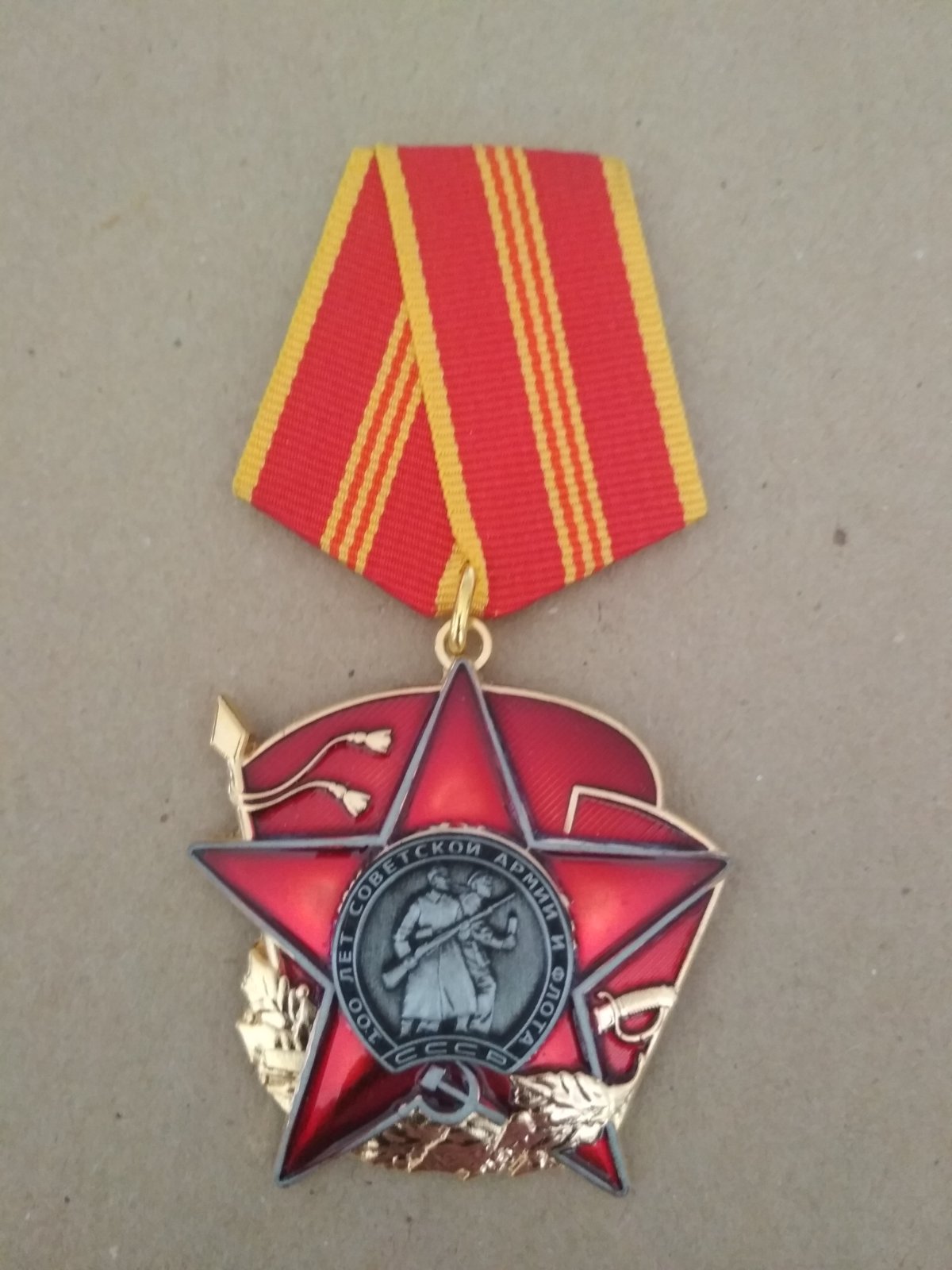 Знак на пятиугольной колодке "100 лет советской армии и флоту". На фоне красного знамени и красной звезды изображение матроса и солдата