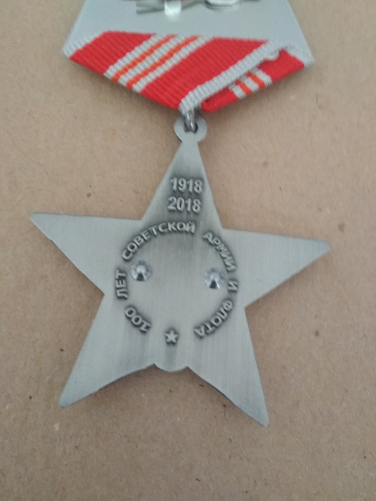 Знак на пятиугольной колодке "100 лет советской армии и флота". В медальоне красной звезды изображение матроса и солдата.