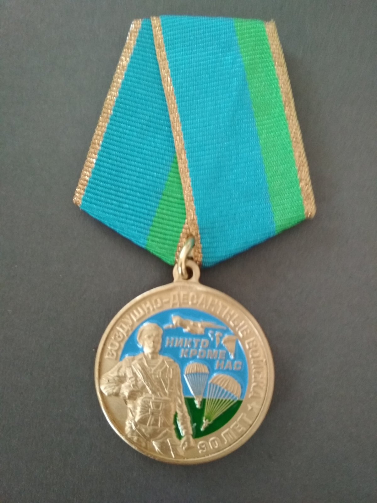 Медаль "90 лет ВДВ". Десантник на фоне флага ВДВ.